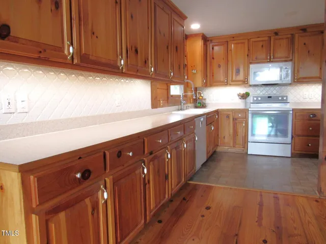 a kitchen with granite countertop wooden cabinets a sink and dishwasher