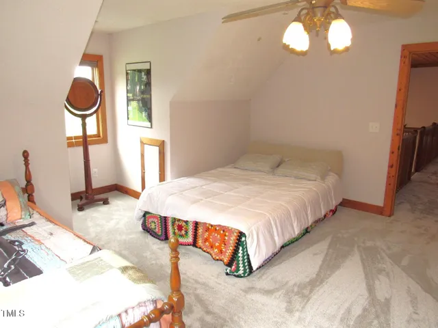 a bedroom with bed and a chandelier