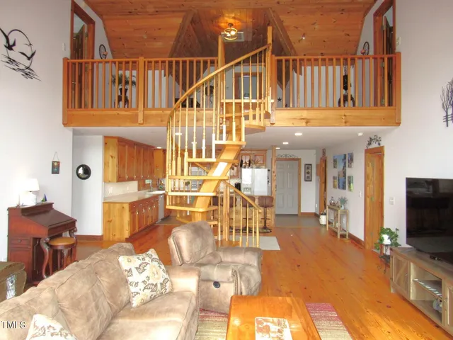 a view of a livingroom with furniture a rug wooden floor and a chandelier