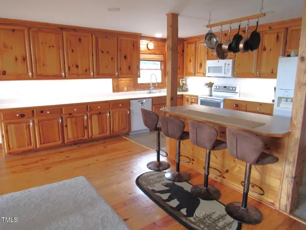 a kitchen with stainless steel appliances a dining table chairs stove and sink