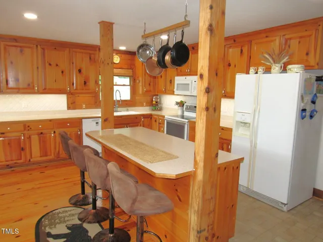 a kitchen with stainless steel appliances a dining table chairs stove and sink