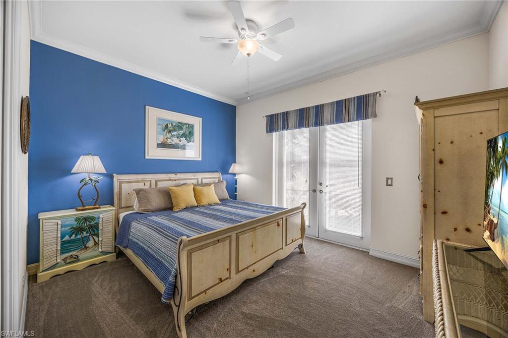 146 Windward Cay Naples, FL 34114 - Photo 20 of 33 a spacious bedroom with a bed and a chandelier