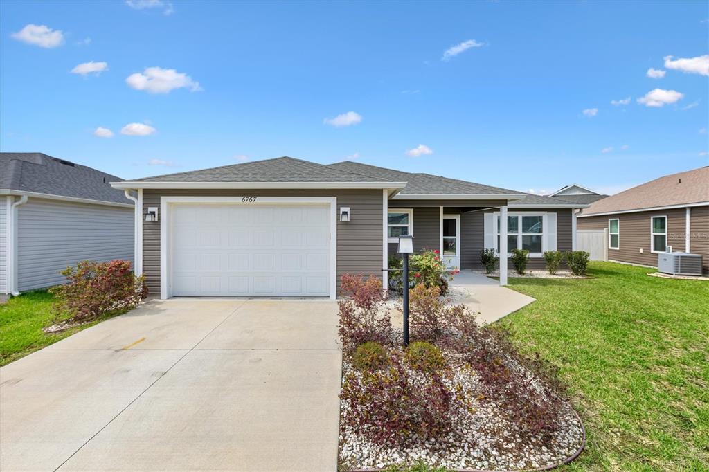 6767 Mary Loop The Villages, FL 34762 - Photo 2 of 26 a front view of a house with garden