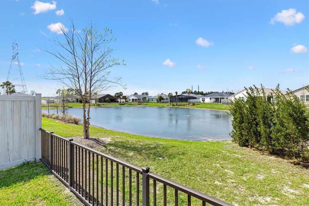 6767 Mary Loop The Villages, FL 34762 - Photo 23 of 26 a view of a lake with a building in the background