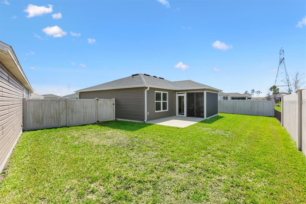 6767 Mary Loop The Villages, FL 34762 - Photo 24 of 26 a view of a backyard with a garden and deck