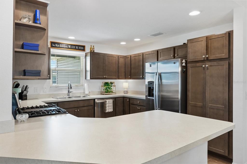 6767 Mary Loop The Villages, FL 34762 - Photo 6 of 26 a kitchen with granite countertop a refrigerator and a sink