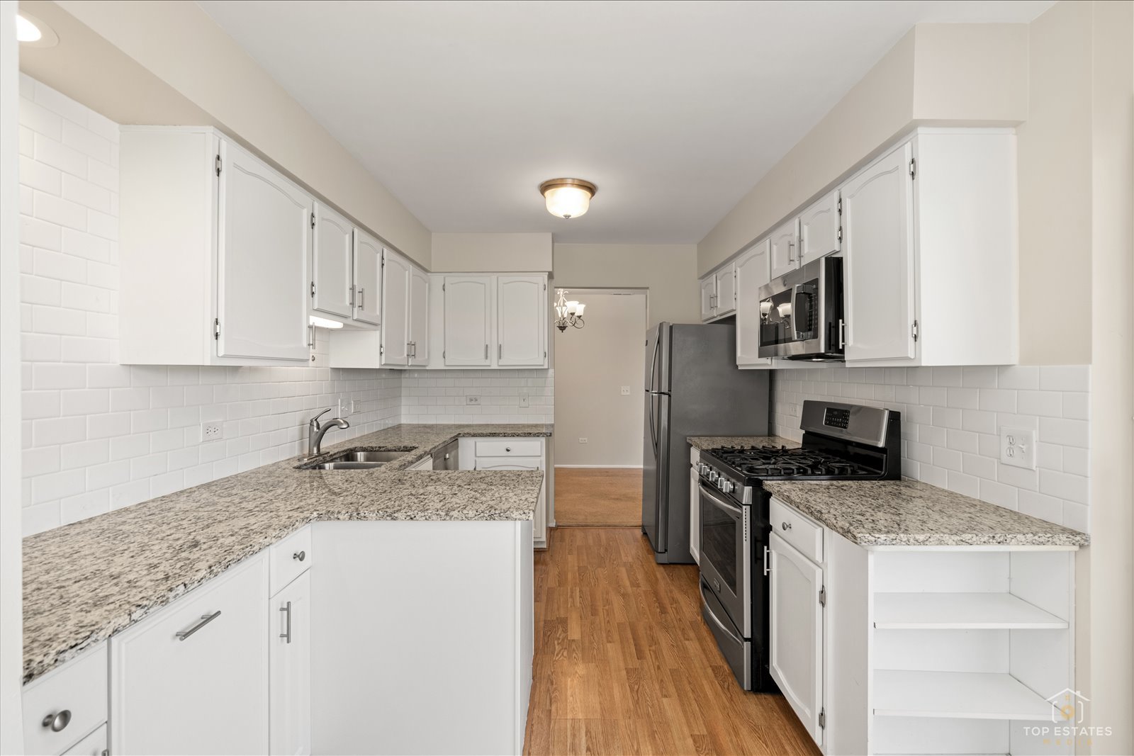 1427 Sutton Court, Unit 1427 Vernon Hills, IL 60061 - Photo 11 of 27 a kitchen with granite countertop a sink a stove top oven a counter space and cabinets