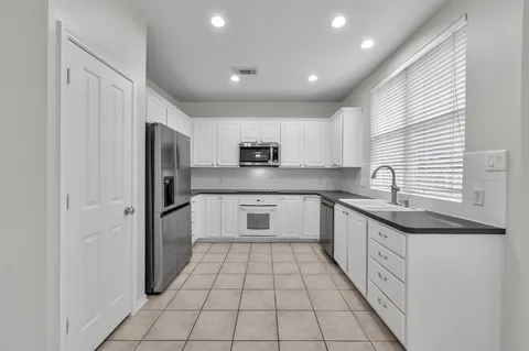 a kitchen with white cabinets and stainless steel appliances