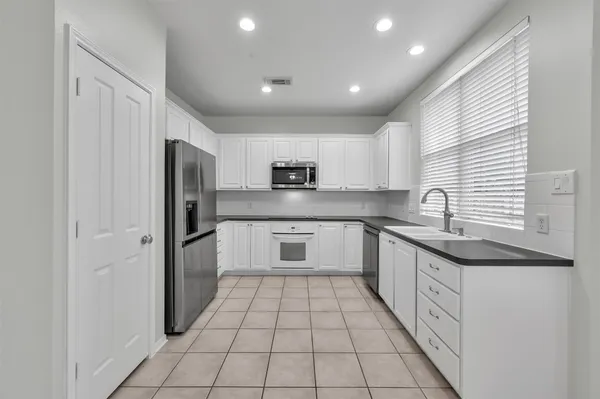 a kitchen with white cabinets and stainless steel appliances