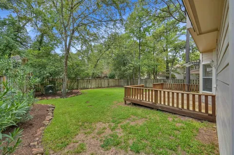 a view of garden with wooden fence and trees
