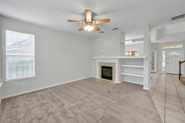 a view of an empty room with a fireplace and a window