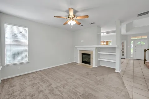 a view of an empty room with a fireplace and a window