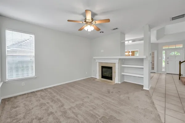 a view of an empty room with a fireplace and a window