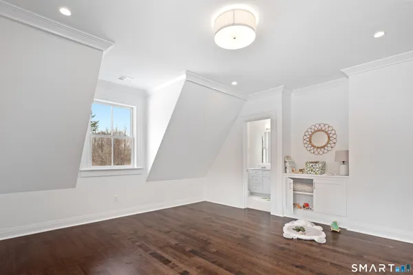 a view of empty room with wooden floor and window