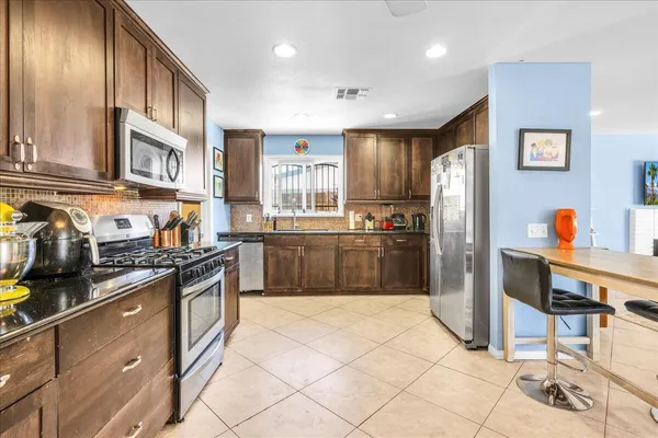a kitchen with stainless steel appliances granite countertop a refrigerator and a stove