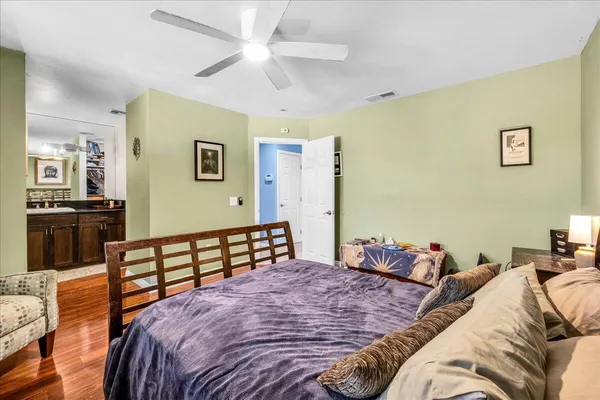 a bedroom with a bed and wooden floor