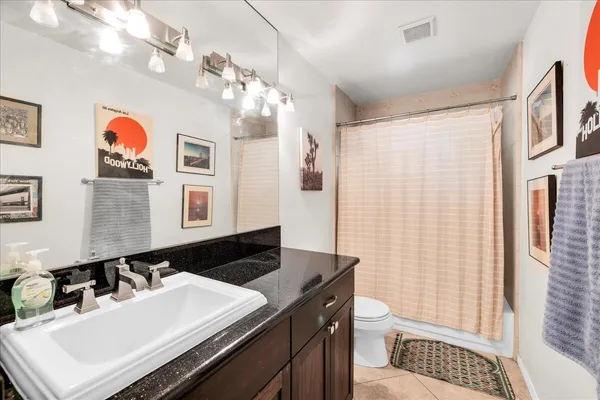 a bathroom with a sink a toilet a mirror and shower curtain