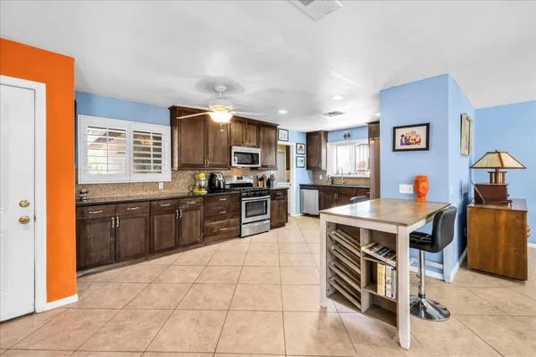 a kitchen with a stove a sink a counter top space and appliances