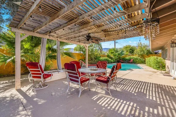 a outdoor space with the couches and dining table with the garden view