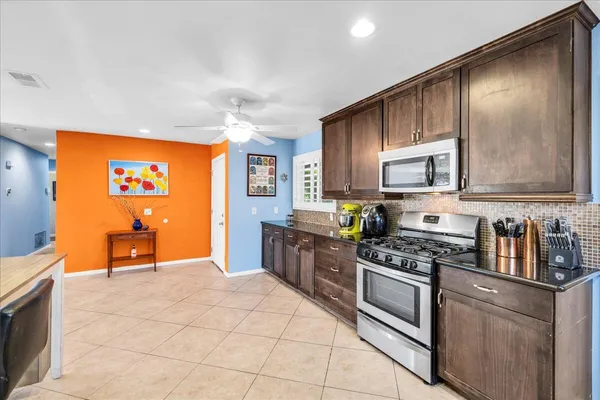 a kitchen with stainless steel appliances granite countertop a stove a sink and a microwave