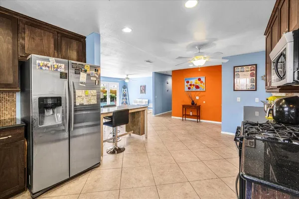 a kitchen with stainless steel appliances granite countertop a refrigerator and a stove top oven