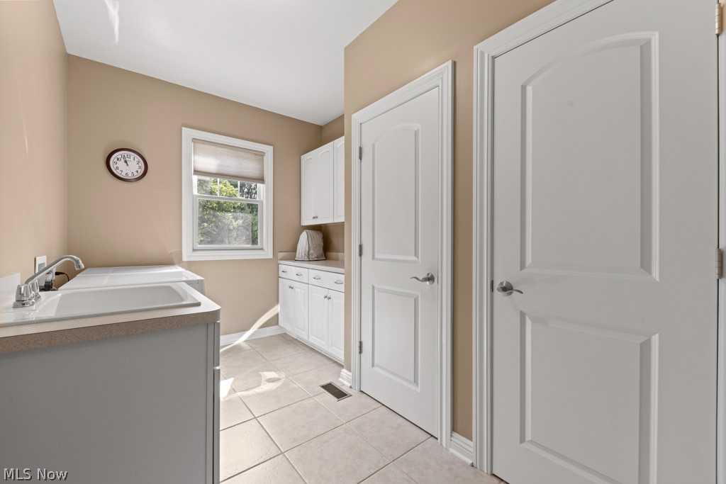 6595 Buffham Road Seville, OH 44273 - Photo 36 of 49 Main level laundry room with utility sink, cabinets, countertop, and two closets