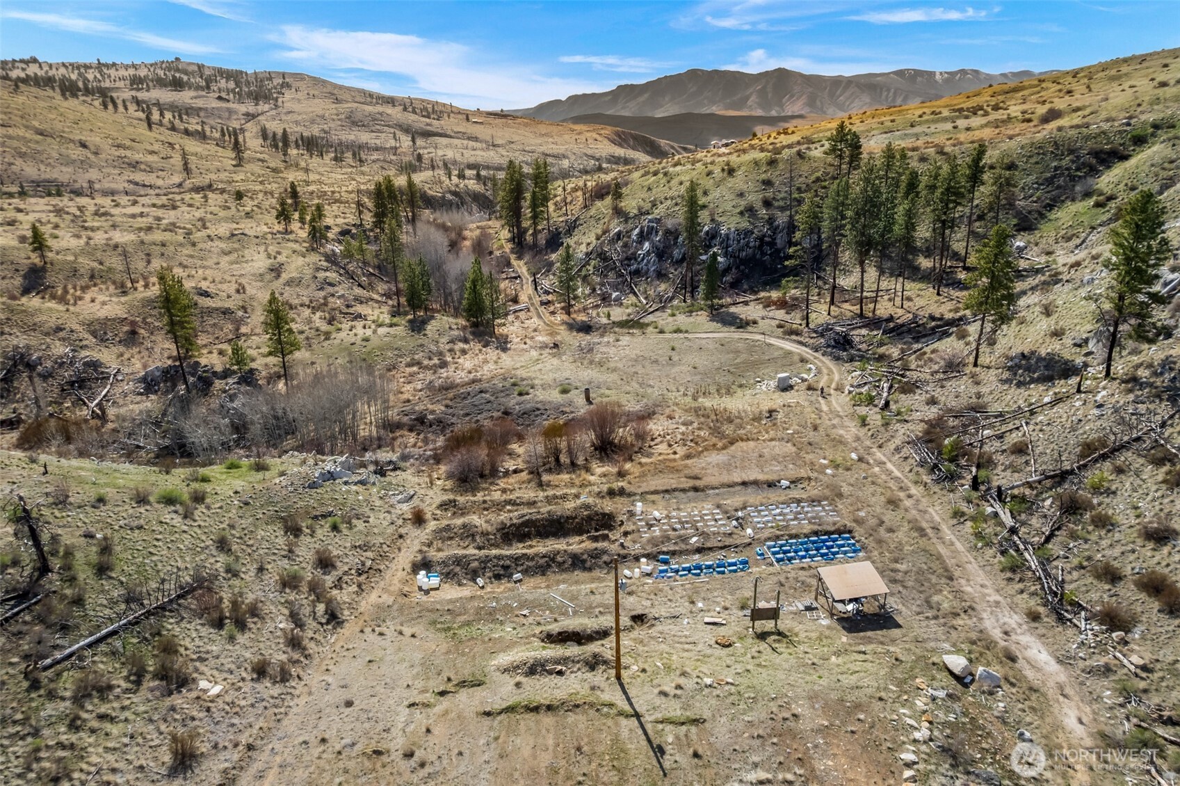 576 Indian Dan Canyon Road Brewster, WA 98812 - Photo 15 of 18 a view of a dry yard with wooden floor and a mountain view