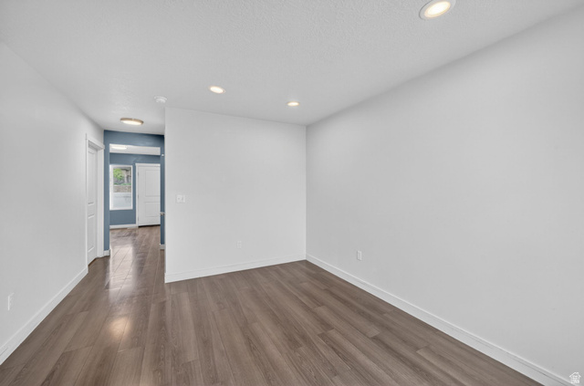 295 Spruce Way Santaquin, UT 84655 - Photo 7 of 32 Spacious room featuring wood-finish flooring, recessed ceiling lighting, crisp white walls, and white baseboards