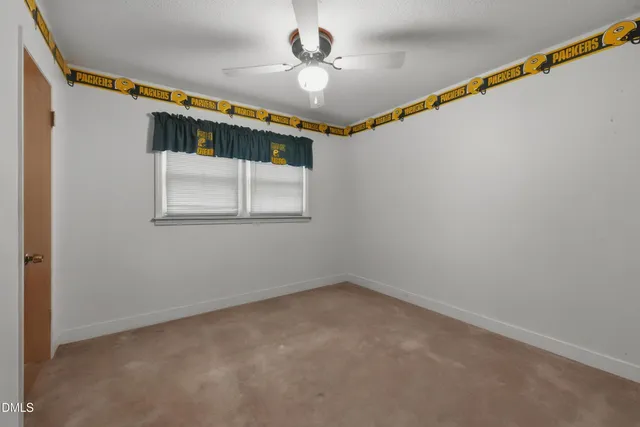 a view of empty room with wooden floor and fireplace