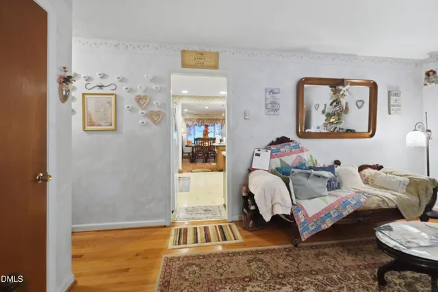 a kitchen with stainless steel appliances granite countertop a stove top oven a sink a dining table and chairs with wooden floor