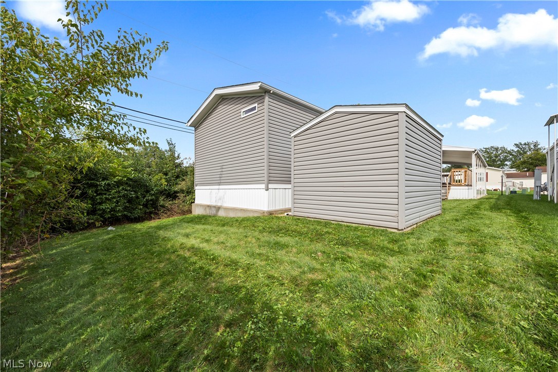 35157 Center Ridge Road, Unit 92 North Ridgeville, OH 44039 - Photo 34 of 40 Rear exterior featuring gray horizontal siding, white trim, and a detached shed