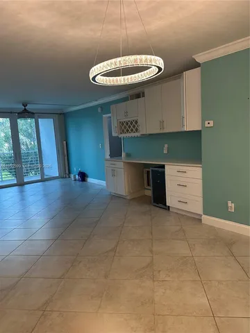 a kitchen with a sink cabinets and chandelier