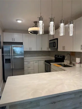 a kitchen with stainless steel appliances granite countertop a sink a stove and a refrigerator