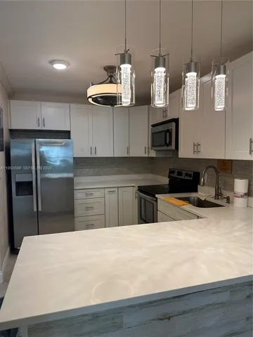 a kitchen with stainless steel appliances granite countertop a sink a stove and a refrigerator