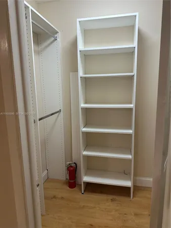 a view of walk in closet with empty racks