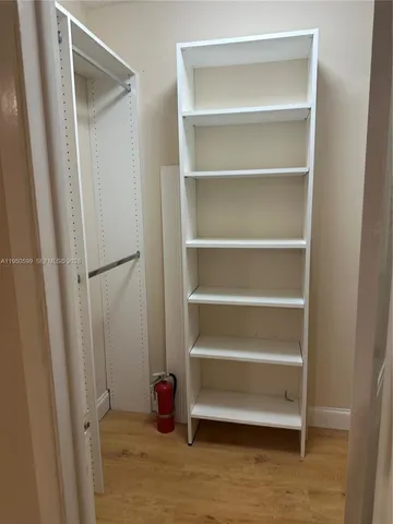 a view of walk in closet with empty racks