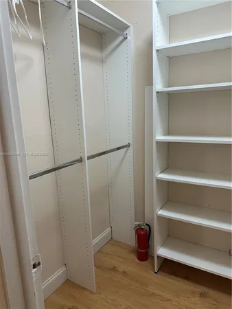 a view of walk in closet with empty racks