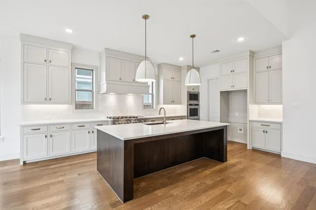 a view of kitchen with stainless steel appliances granite countertop cabinets and wooden floor