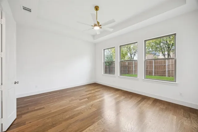 a view of big room with wooden floor and windows
