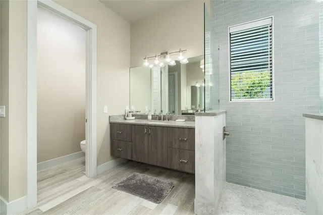 a bathroom with a sink a toilet and shower