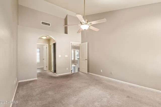 an empty room with a ceiling fan and a bathroom