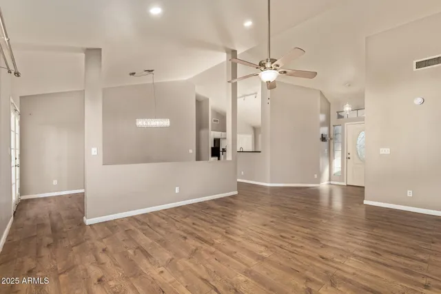 a view of a big room with wooden floor and a ceiling fan