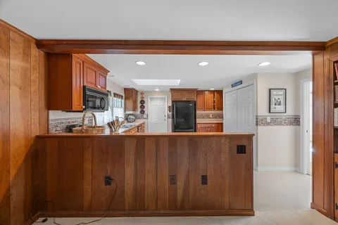 a view of kitchen with stainless steel appliances granite countertop cabinets and a refrigerator