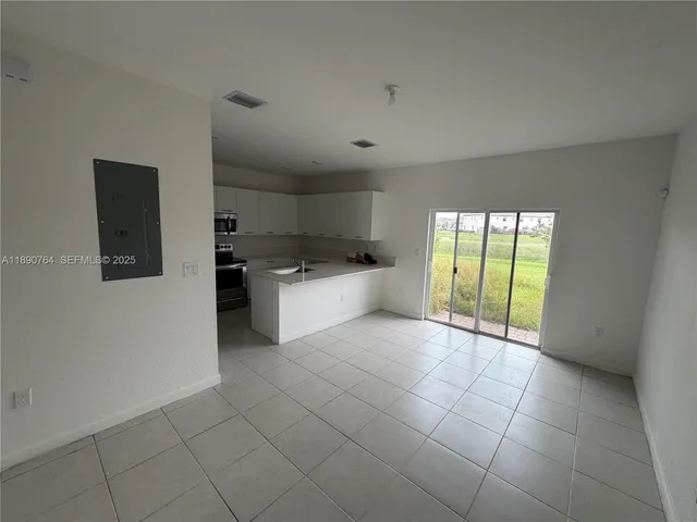 a large white kitchen with a sink and dishwasher a refrigerator with white cabinets