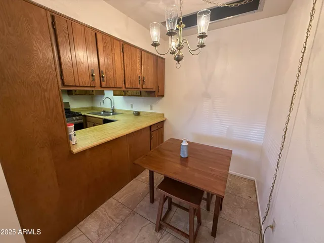 a room with stainless steel appliances a table and chair