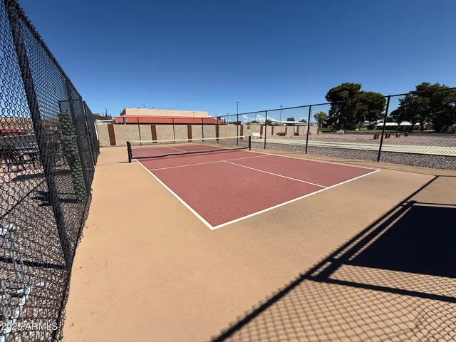 a tennis court with view of houses