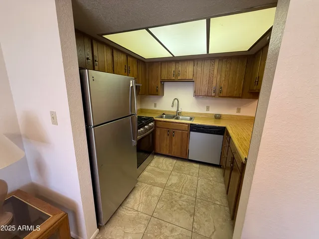a kitchen with stainless steel appliances granite countertop a refrigerator sink and cabinets