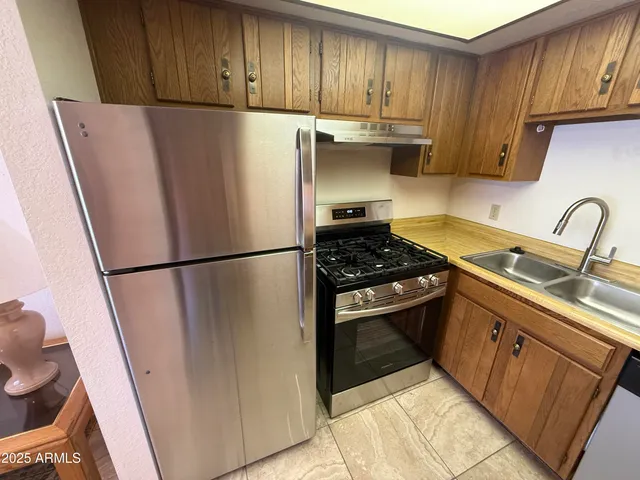 a kitchen with a refrigerator sink and cabinets