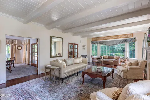 a view of a dining room with furniture a chandelier and wooden floor