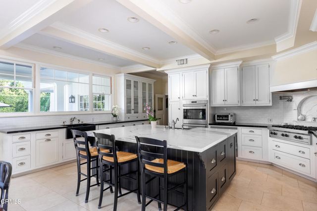 a kitchen with granite countertop white cabinets and window